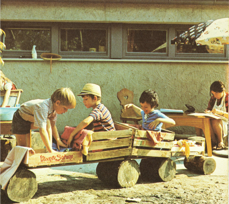 Kinder bauen aus Holzkisten und Baumstämmen ein Fahrzeug