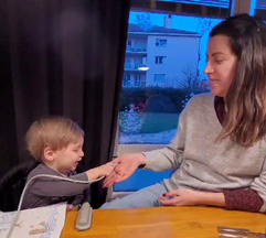 Ein Kind gibt einer Frau etwas.