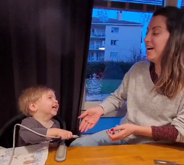 Ein Kind und eine Frau lachen zusammen.